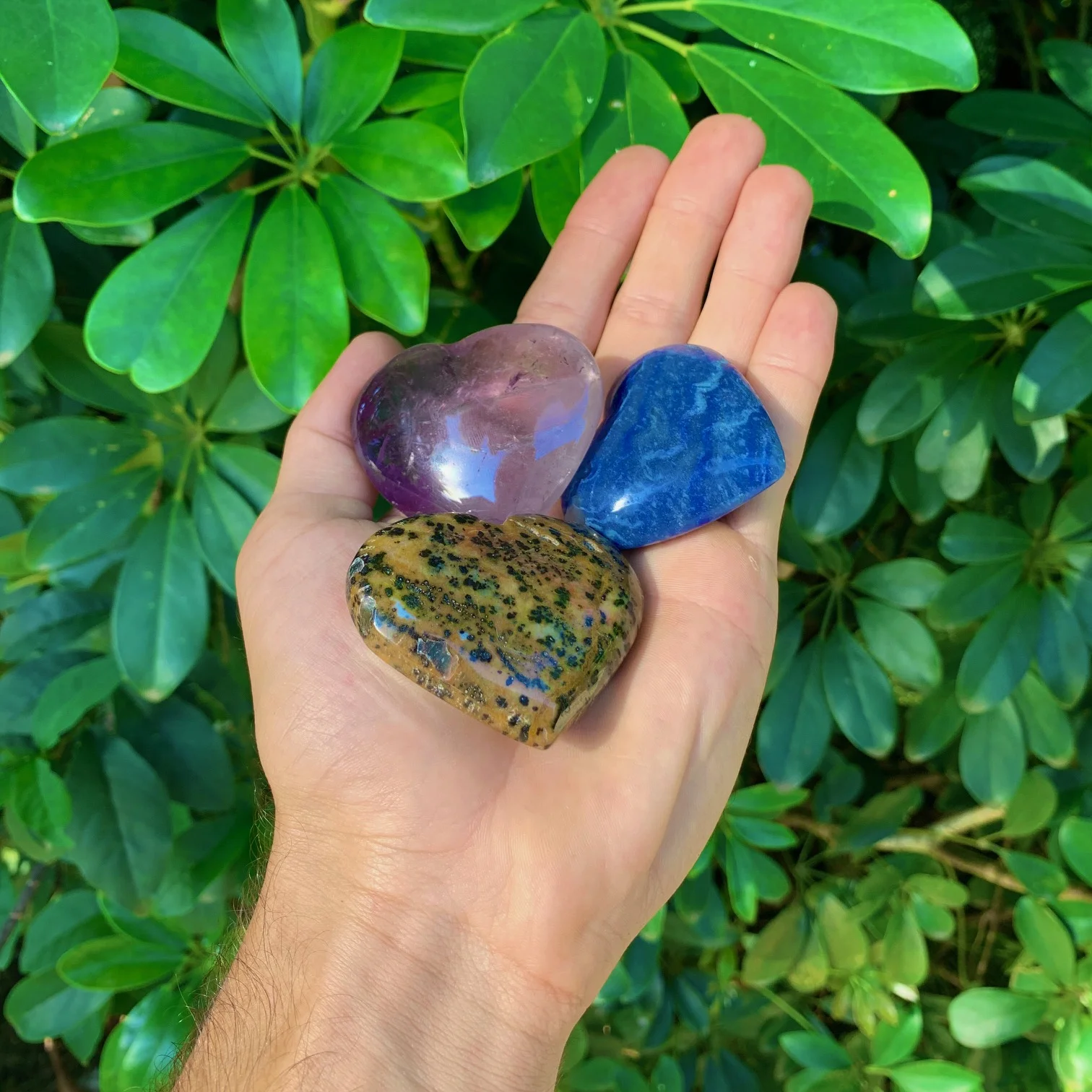 Heart-shaped minerals being held by one hand